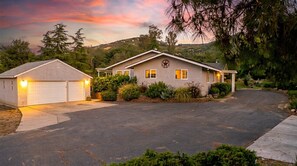 A residential property with a garage, a driveway, and a house with a front porch.