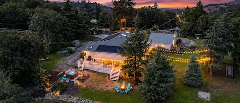 A house with a deck, outdoor seating, and a fire pit.