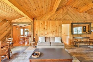 Un intérieur chaleureux, avec des éléments en bois, comprenant un canapé, une table à manger et des bancs.