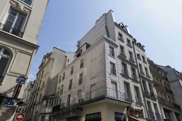 A multi-story building with balconies and signage for Georges Z.