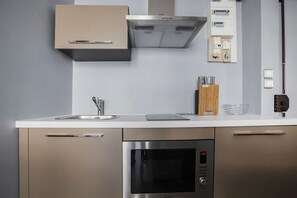 Una cocina moderna con electrodomésticos de acero inoxidable, horno empotrado y microondas.