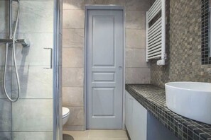 A bathroom with a shower, toilet, and sink.