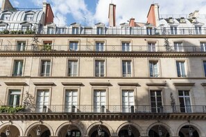 Un edificio de varios pisos con un estilo arquitectónico clásico, con ventanas y balcones simétricos.