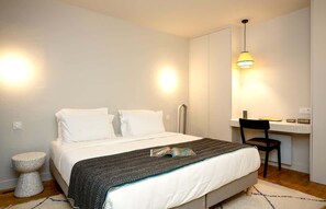 Un dormitorio con una cama, un escritorio y una silla.