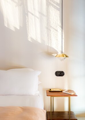 A bedroom with a bed, a bedside table with a lamp, and a small wall-mounted device. - Grand apartment with character facing the Louvre - 3 bedrooms - A/C - up to 8 guests - Rivoli III by Habitat Parisien (Paris)