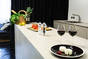 Uma cozinha moderna com bancada, duas taças de vinho, um prato com comida e utensílios de cozinha.