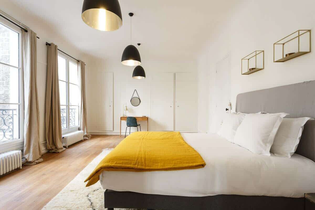 Une chambre moderne avec un grand lit, un bureau et une vue sur l’extérieur.