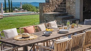 An outdoor dining area with a stone staircase, a pool, and a view of the mountains.