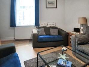 A living room with a sofa, a coffee table, and a lamp.