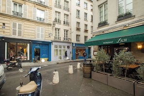 A street with a restaurant named SALIVI, a blue storefront, and a scooter parked on the sidewalk. - Charming duplex in the heart of le Marais - 1 bedroom - A/C - boutiques at the door - Marais Sicile Duplex by Habitat Parisien (Paris)