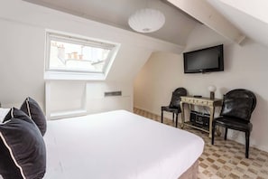 A bedroom with a large bed, a desk with a chair, a television, and a window with a view of buildings. - Charming duplex in the heart of le Marais - 1 bedroom - A/C - boutiques at the door - Marais Sicile Duplex by Habitat Parisien (Paris)