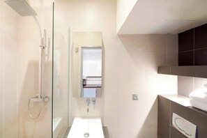 A modern bathroom with a glass-enclosed shower, a white sink, and a mirror above it. - Cosy studio in the heart of le Marais - A/C - Steps from the Pompidou Centre - Marais Sicile I by Habitat Parisien (Paris)