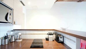 A modern kitchen with a built-in stove, coffee maker, and toaster. - Cosy studio in the heart of le Marais - A/C - Steps from the Pompidou Centre - Marais Sicile I by Habitat Parisien (Paris)