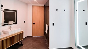 A modern bathroom with a vanity, mirror, and recessed lighting. - HOTEL LUURE  (Huixquilucan)