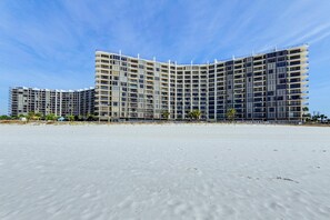 A modern hotel with a curved facade, multiple balconies, and a beach view. - Edgewater Golf Villa 3204 (Panama City Beach)