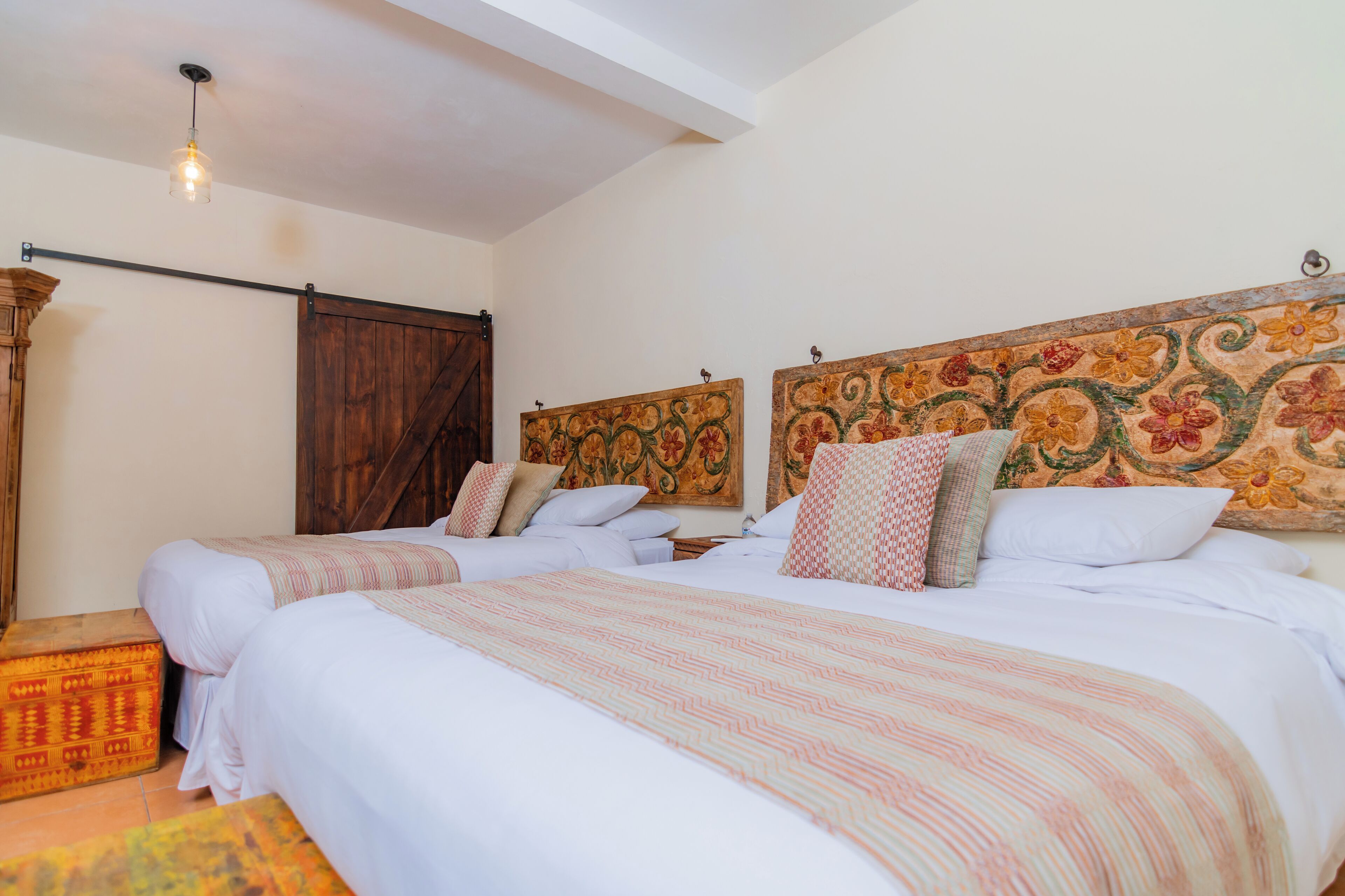 A bedroom with two beds, wooden headboards, and a rustic decor.