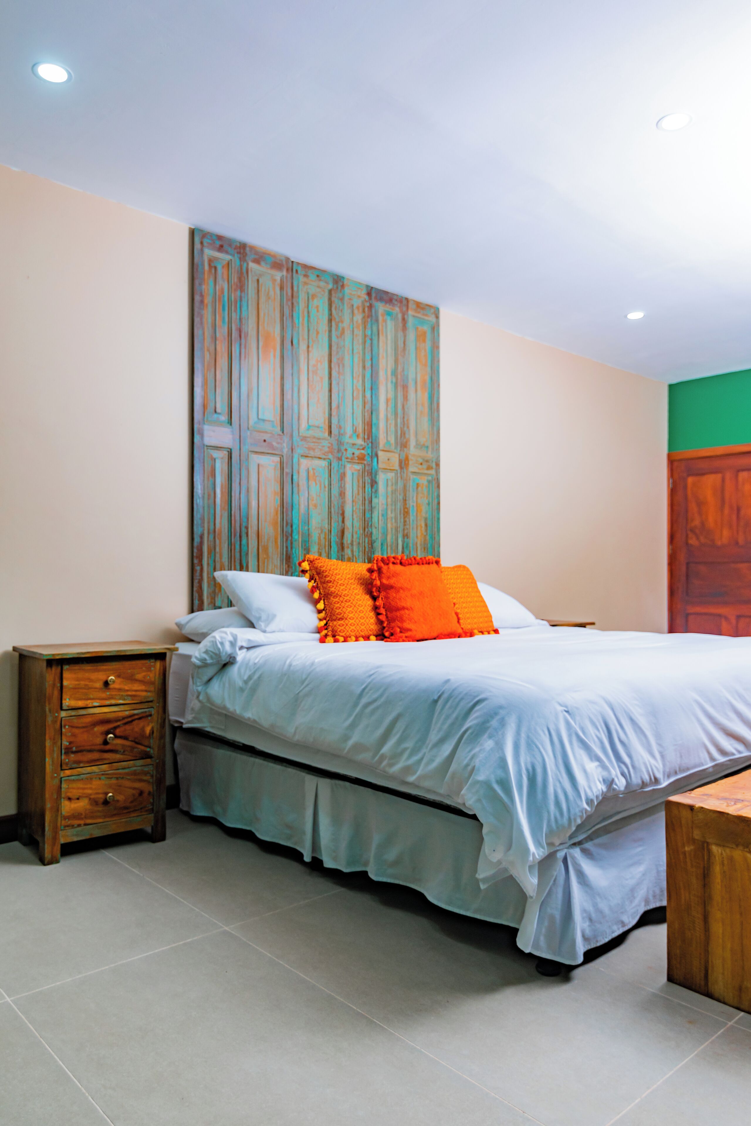A bedroom with a bed, a nightstand, and a wooden cabinet.
