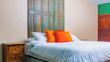 A bedroom with a bed, a nightstand, and a wooden cabinet.