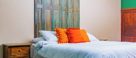 A bedroom with a bed, a nightstand, and a wooden cabinet.