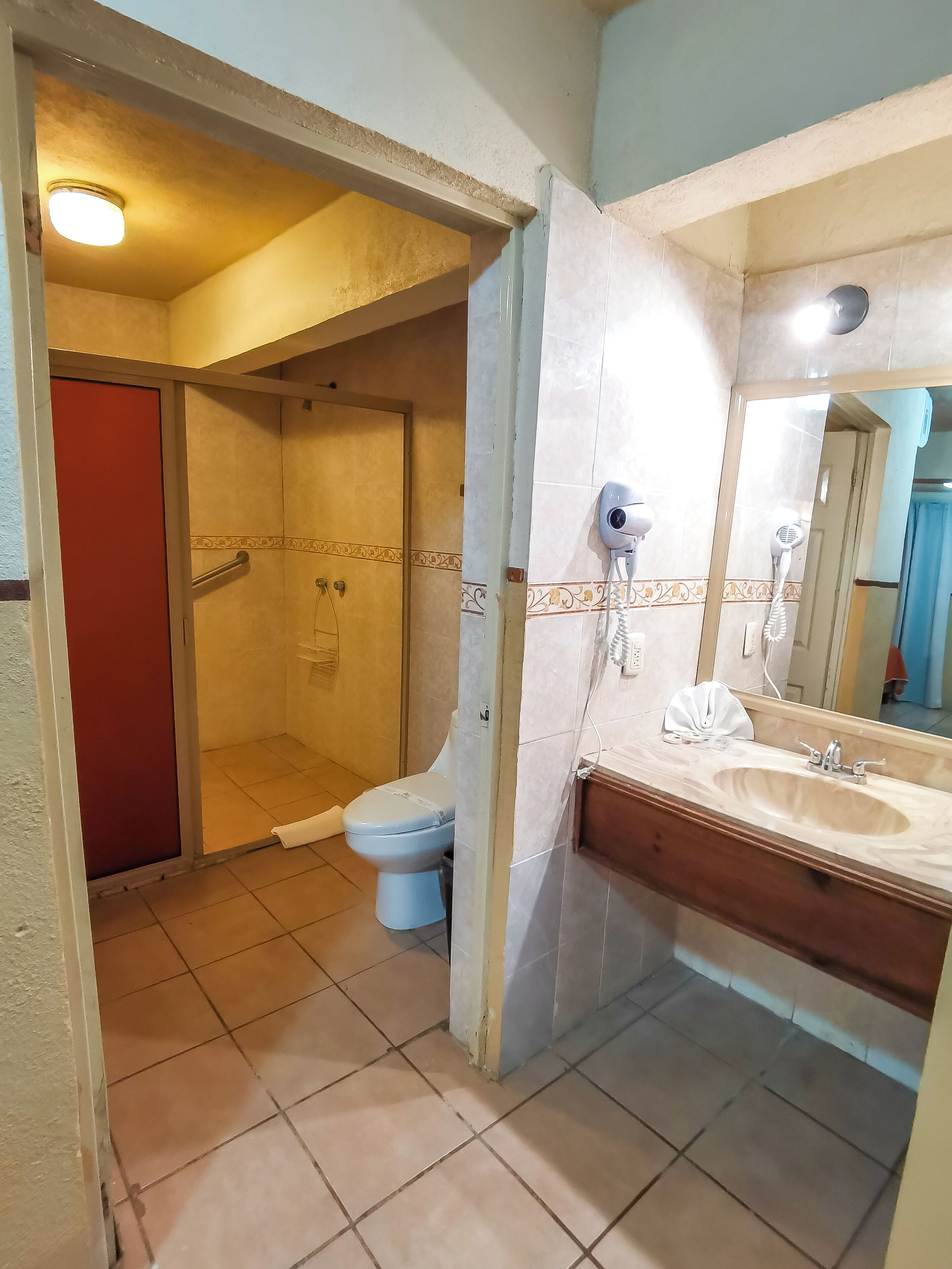 Un baño con ducha, inodoro y lavamanos.