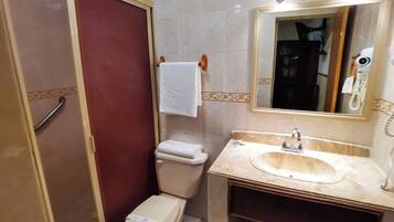 Un baño con inodoro, lavamanos y espejo.