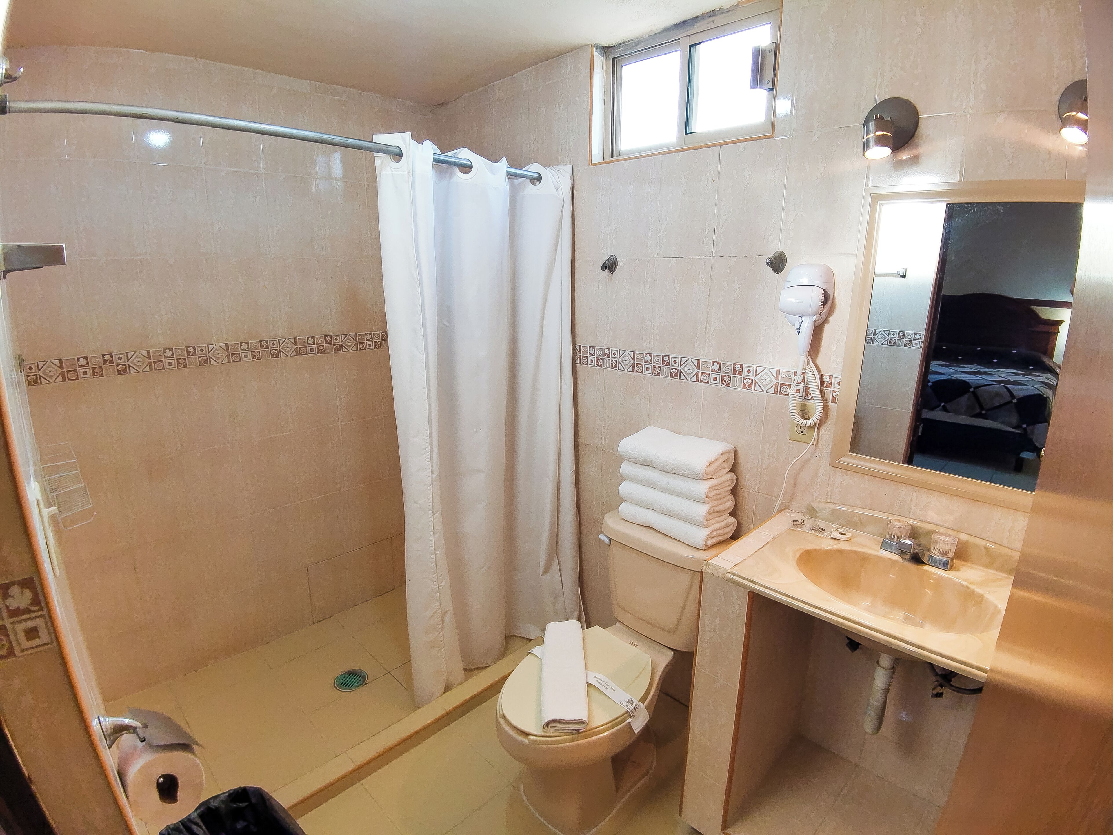 Ein Badezimmer mit Dusche, Toilette, Waschbecken und Spiegel.