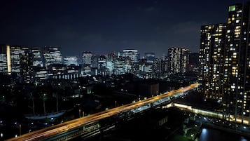 A nighttime cityscape with illuminated skyscrapers and a multi-level highway.