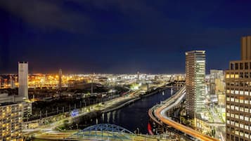 A nighttime cityscape with a river, bridges, and high-rise buildings.