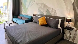 Una camera da letto moderna con un letto grande, un divano e un affresco sulla parete.