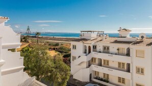 A coastal building with multiple balconies, a clear view of the beach, and a Mediterranean architectural style. - Casa Londamba | Meia Praia Beach House | Lagos Sea View (Lagos)