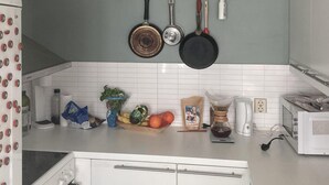 A kitchen with white cabinets, a coffee maker, a toaster, and various kitchen utensils and food items on the counter. - Lovely home in Flaktveit with WiFi (Flaktveit)