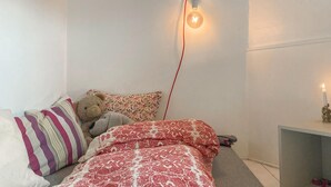 A bedroom with a bed, pillows, a teddy bear, a wall-mounted light, and a candle on a nightstand. - Lovely home in Flaktveit with WiFi (Flaktveit)