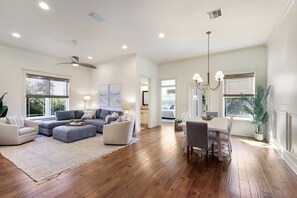 A spacious living area with a sectional sofa, a dining table with chairs, and a ceiling fan. - Pool Heated & Private, Close to Beach, Luxury Home (Holmes Beach)