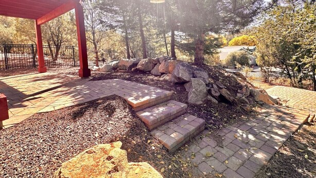 A stone staircase leading up to a red pergola in a park setting. - Villa Hermosa- Guest Quarters (Prescott)