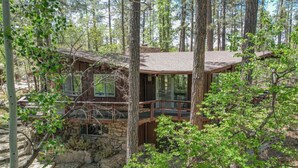 A cabin with a stone foundation, wooden exterior, and a balcony. - Morning Bliss - Multi Family & Couples (Prescott)