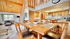 A spacious living area with a wooden dining table, chairs, and a staircase leading to an upper level. - NEW - Peakview Lodge - Fireplace- Views (Prescott)