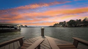 Eine Holzsteg mit Bänken, der auf ruhiges Wasser bei Sonnenuntergang blickt.