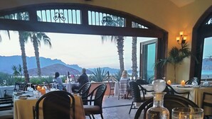 Comedor con mesas dispuestas para dos, velas y un menú.