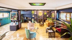 Un vestíbulo amplio con chimenea, zona de estar y mostrador de recepción.