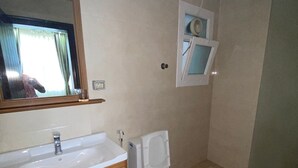 A bathroom with a sink, mirror, toilet, and a small window. - Very nice and relaxing (Salalah)