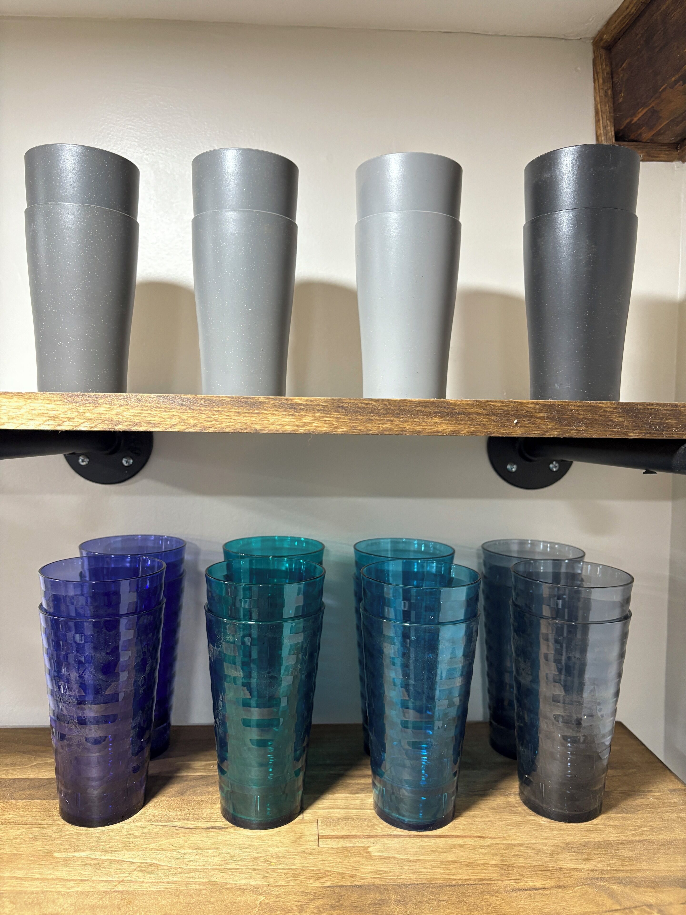 A shelf with gray and blue plastic cups.