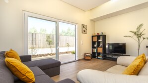 A living room with a grey sofa, a white sofa, and a TV stand with a flat-screen TV. - Peaceful villa w/ pool, BBQ & ping-pong table (Alcantarilha)