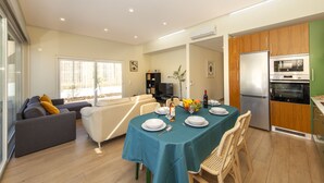 A modern living space with a dining area, sofa, and kitchen. - Peaceful villa w/ pool, BBQ & ping-pong table (Alcantarilha)