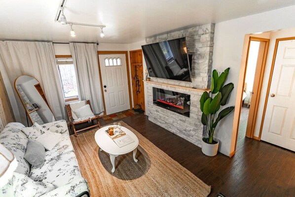 Smart TV, chimenea, libros y estéreo