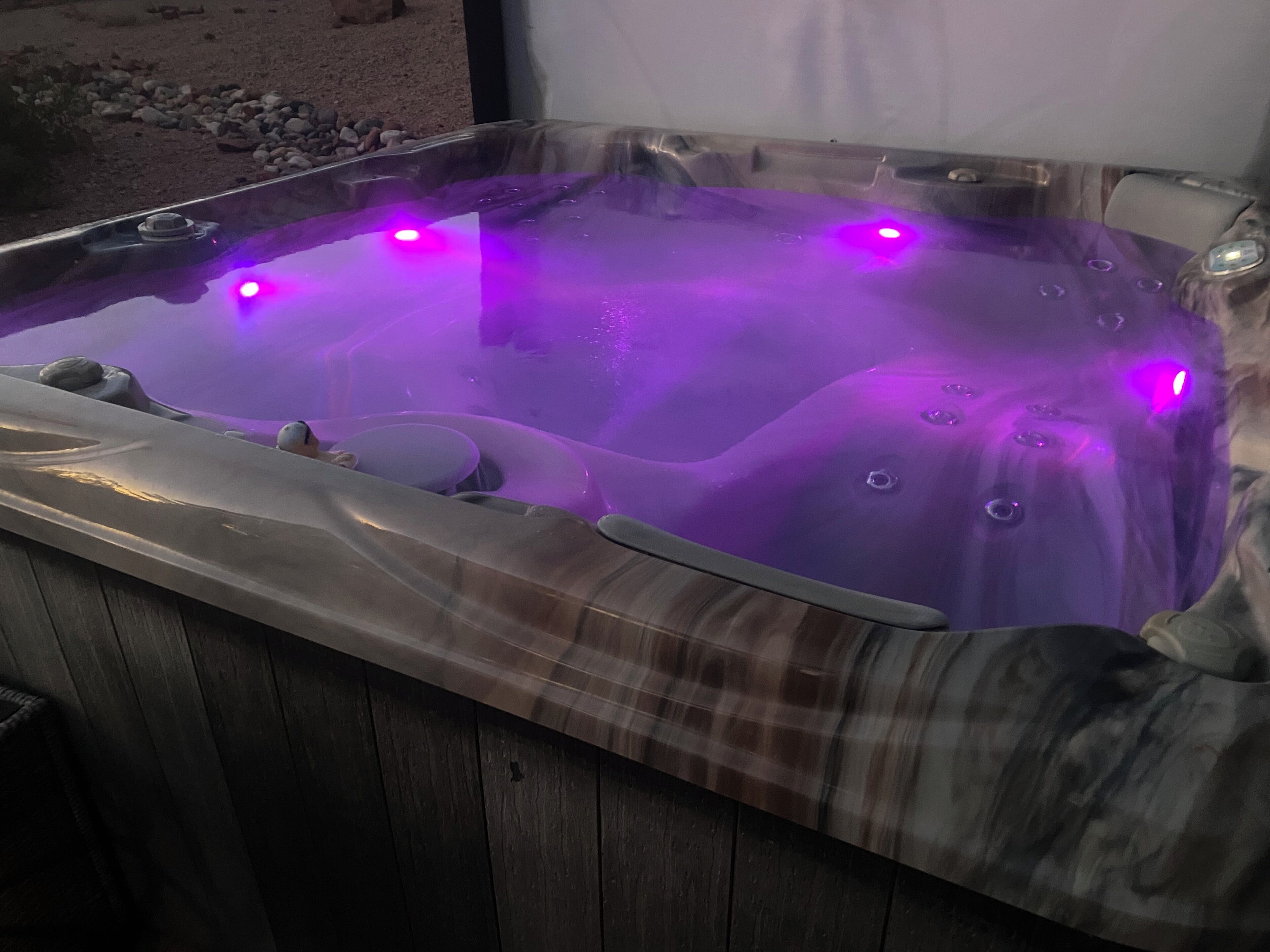 A hot tub with a wooden exterior and a clear interior.