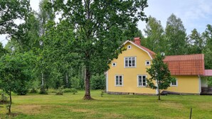 A yellow two-story house with a red roof, surrounded by green trees and grass. - 3 bedroom stunning home in Tingsryd (Tingsryd)