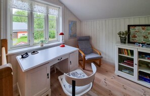 Relax in a peaceful room with a sloped ceiling, featuring a desk, chair, and bookshelf.