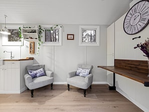 Relax in a clean, minimalist space with two armchairs and a bench, perfect for conversation.