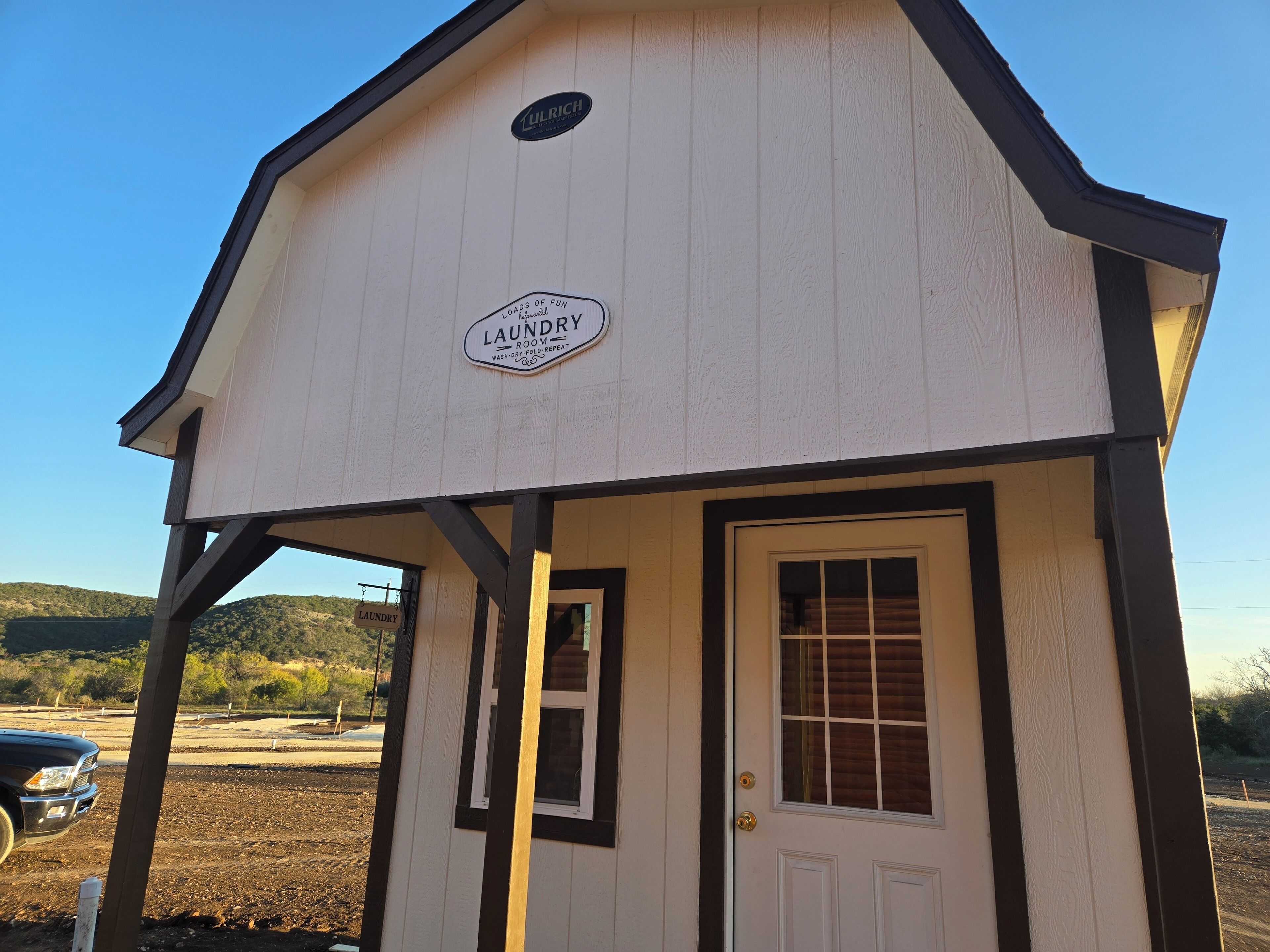 A small laundry facility with a sign indicating it offers loads of fun, a wash-dry-fold-repeat service.