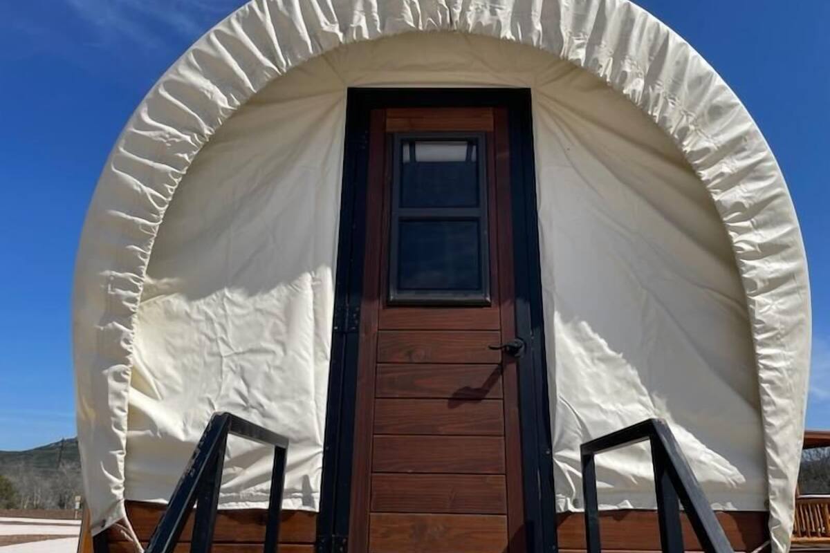 Una estructura de madera cubierta con una puerta y escalones que la conducen.